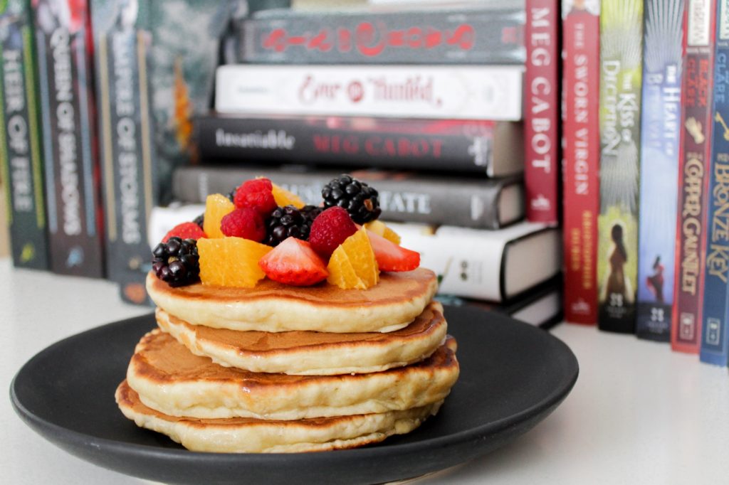 A plate of healthy pancakes topped with fresh fruits