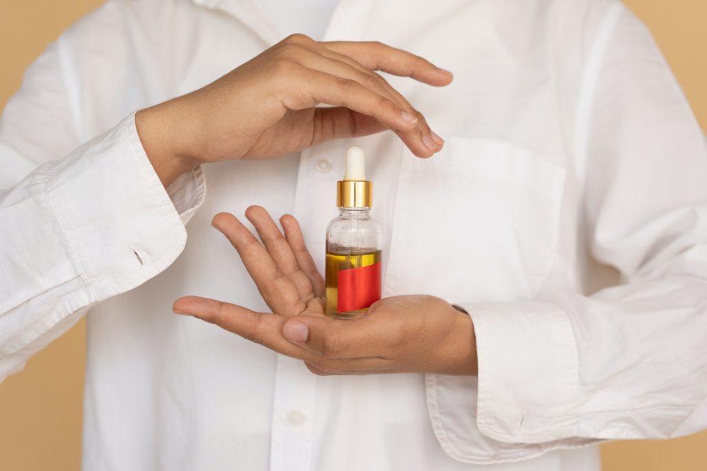 A woman holds a bottle of oil 