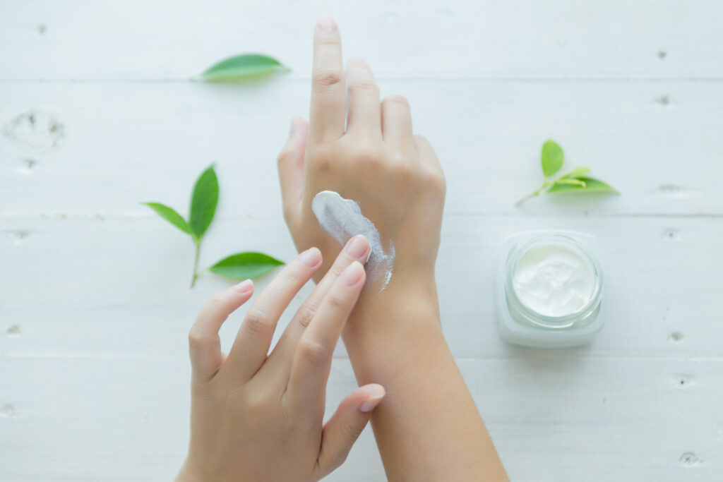 A woman applies a moisturizer to her hand to keep it healthy