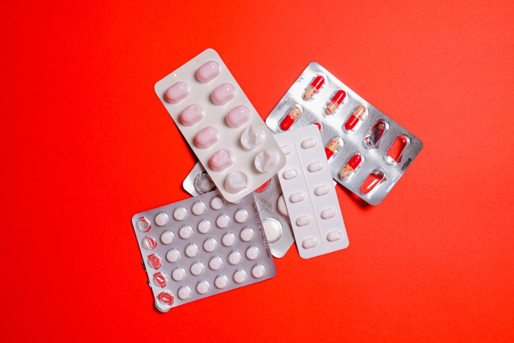 Some medications and supplements on a red background