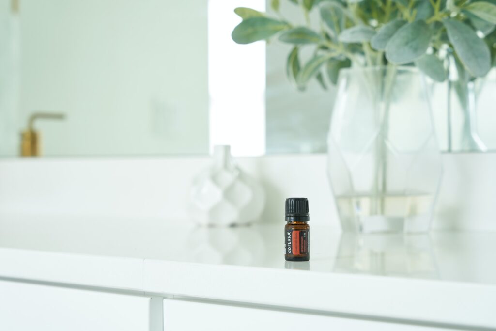 A small bottle of essential oil on white table  