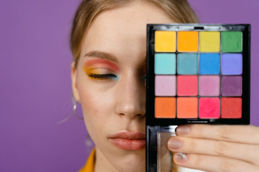 A woman holding an eyeshadow palette 